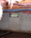 Idaho crawl space with vents, showing mold, rot, and fiberglass insulation dripping off the ceiling.