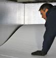 contractor installing TerraBlock™ floor insulation in a Lewiston crawl space