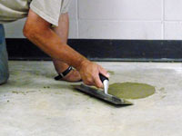 Repairing the cored holes in the concrete slab floor with fresh concrete and cleaning up the Lewiston home.
