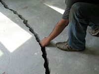 a severely damaged cracked concrete slab floor in Hayden
