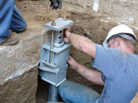 Foundation repair contractors installing the foundation bracket in Pocatello.