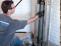 Driving foundation piers into the floor in Rexburg.