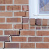 long jagged cracks starting at the corner of a window along a brick wall on a Jerome home