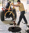 Digging a hole in the garage floor to make room for a wall anchor installation in Rathdrum, Idaho