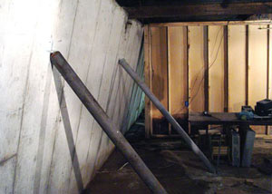 A severely tilting foundation wall propped up by steel beams in .