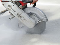 Cutting the driveway for expansion joints during street creep repair in Burley