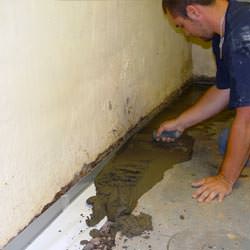 A basement waterproofer installing a perimeter drain system in Hayden
