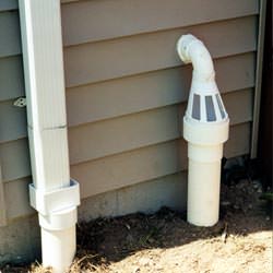 A grated sump pump discharge line fitting in Kuna