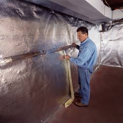 Installation of a radiant heat and vapor barrier on a basement wall in Kuna