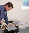 installing a waterproof vapor barrier on a basement floor to prepare for basement carpeting in a Nampa home