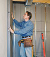 Insulated basement wall panels being placed against a concrete foundation wall in Twin Falls